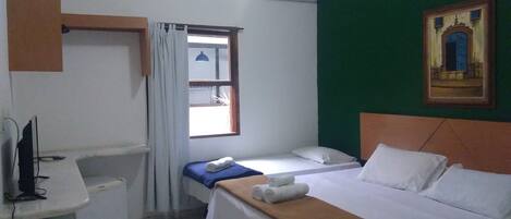 Una habitación pequeña y limpia con una cama, un escritorio y una ventana.