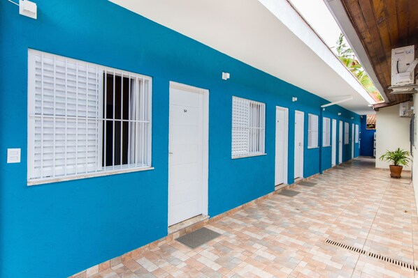 A hallway with blue walls, white doors, and a tiled floor.