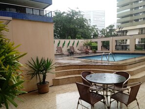 Una piscina al aire libre, sillones reclinables de piscina