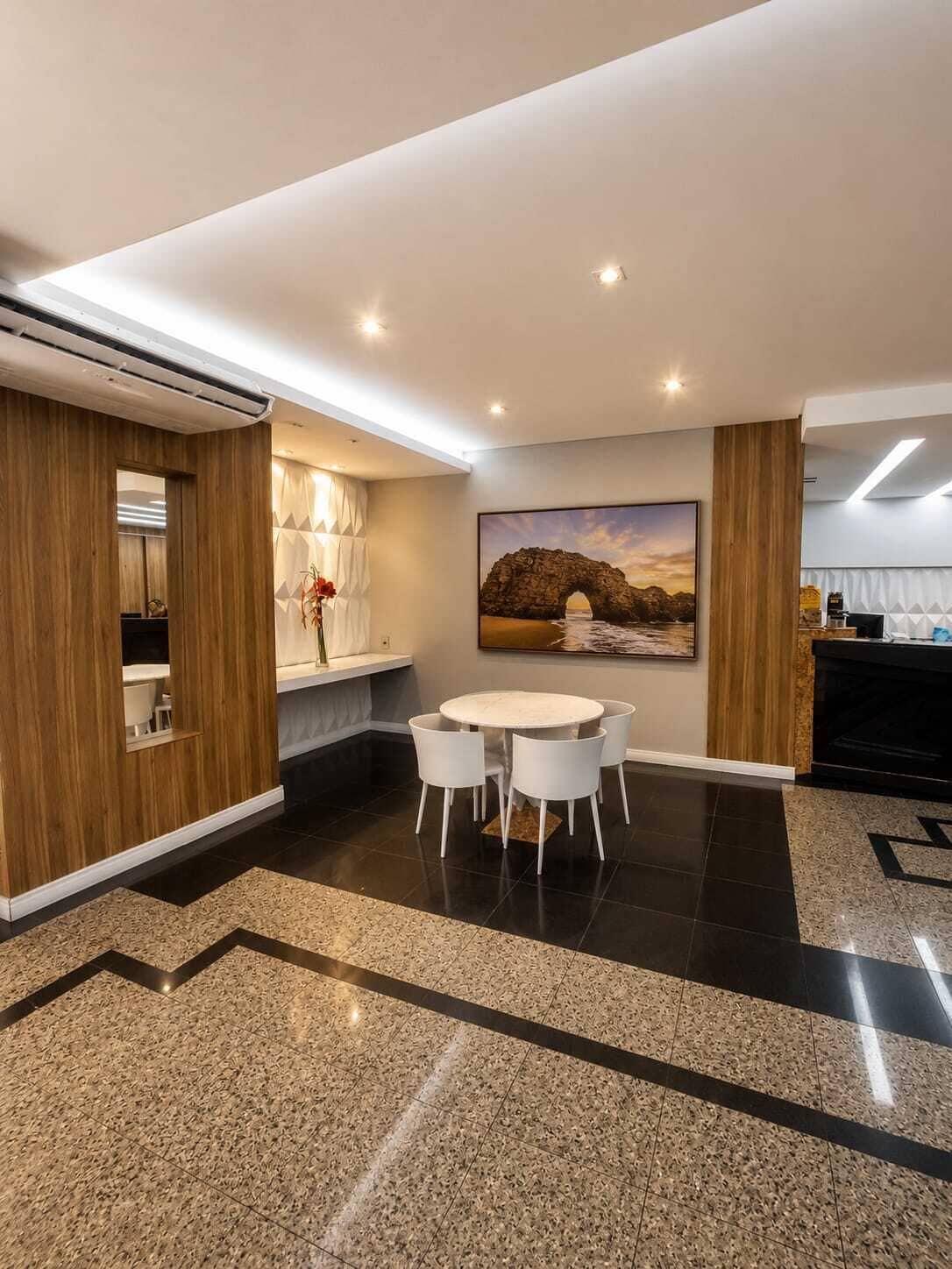 A modern interior with a dining area, a painting of a bridge, and a kitchen area.