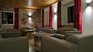 Un salon moderne avec des canapés en cuir, une table basse en bois et des rideaux rouges.