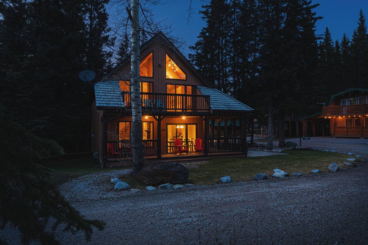 A cabin with a large porch, a dining area, and a visible fireplace.