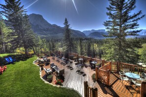 A deck with outdoor seating and a view of mountains. - Overlander Mountain Lodge (Jasper East)
