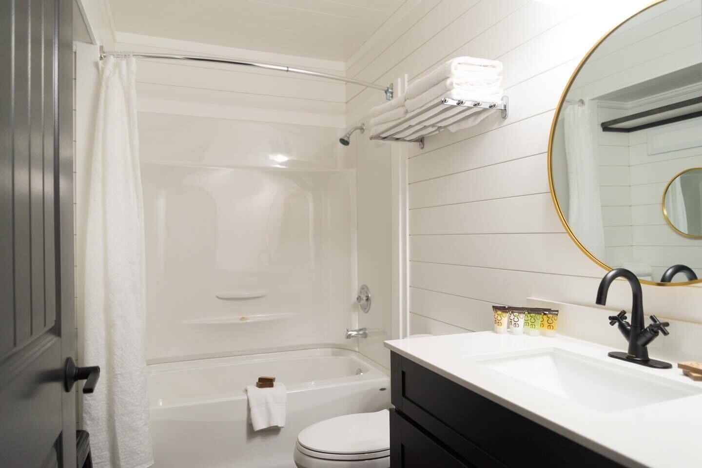 A modern bathroom with a bathtub, toilet, and sink.