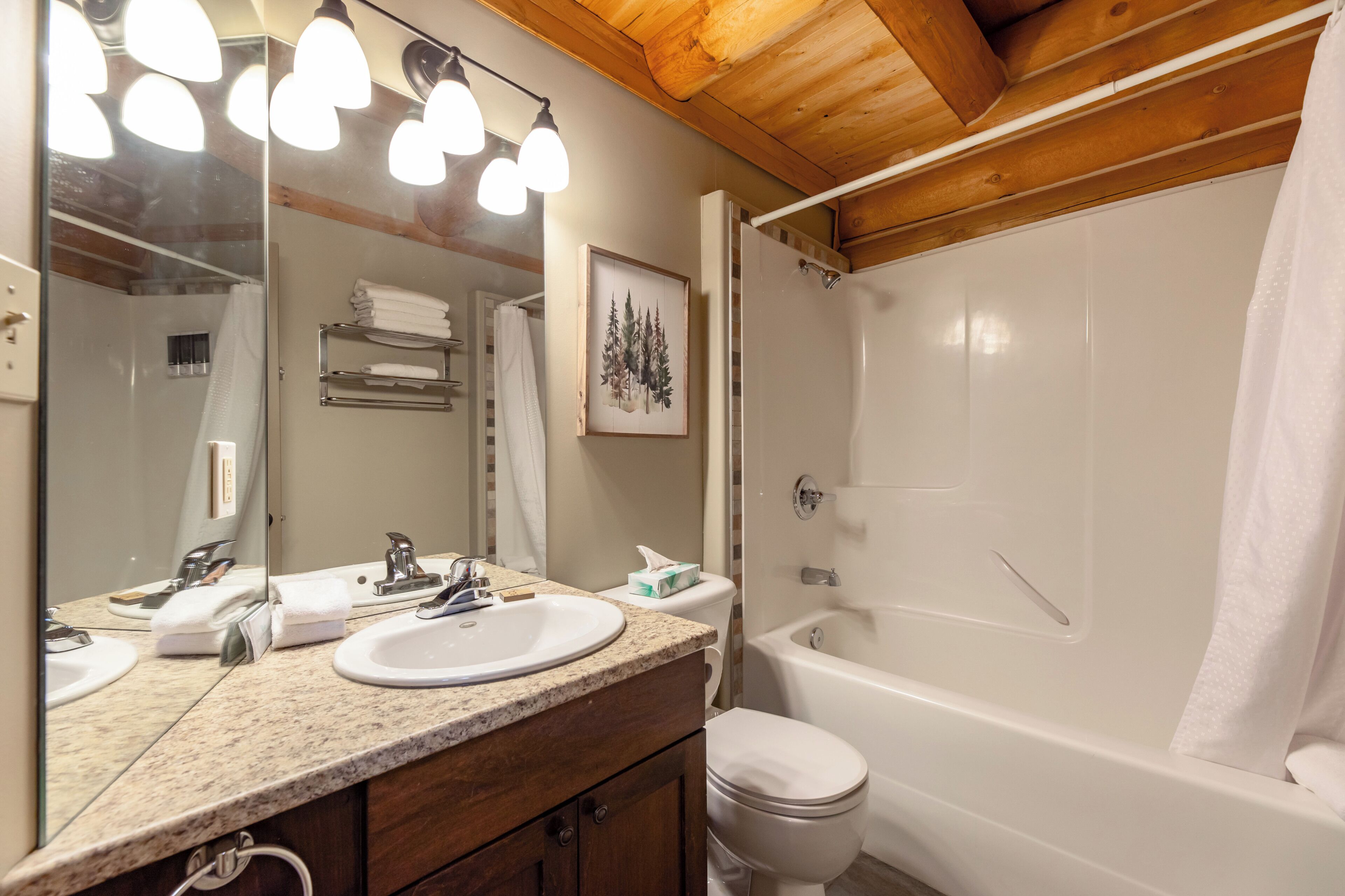 A bathroom with a sink, mirror, and bathtub.