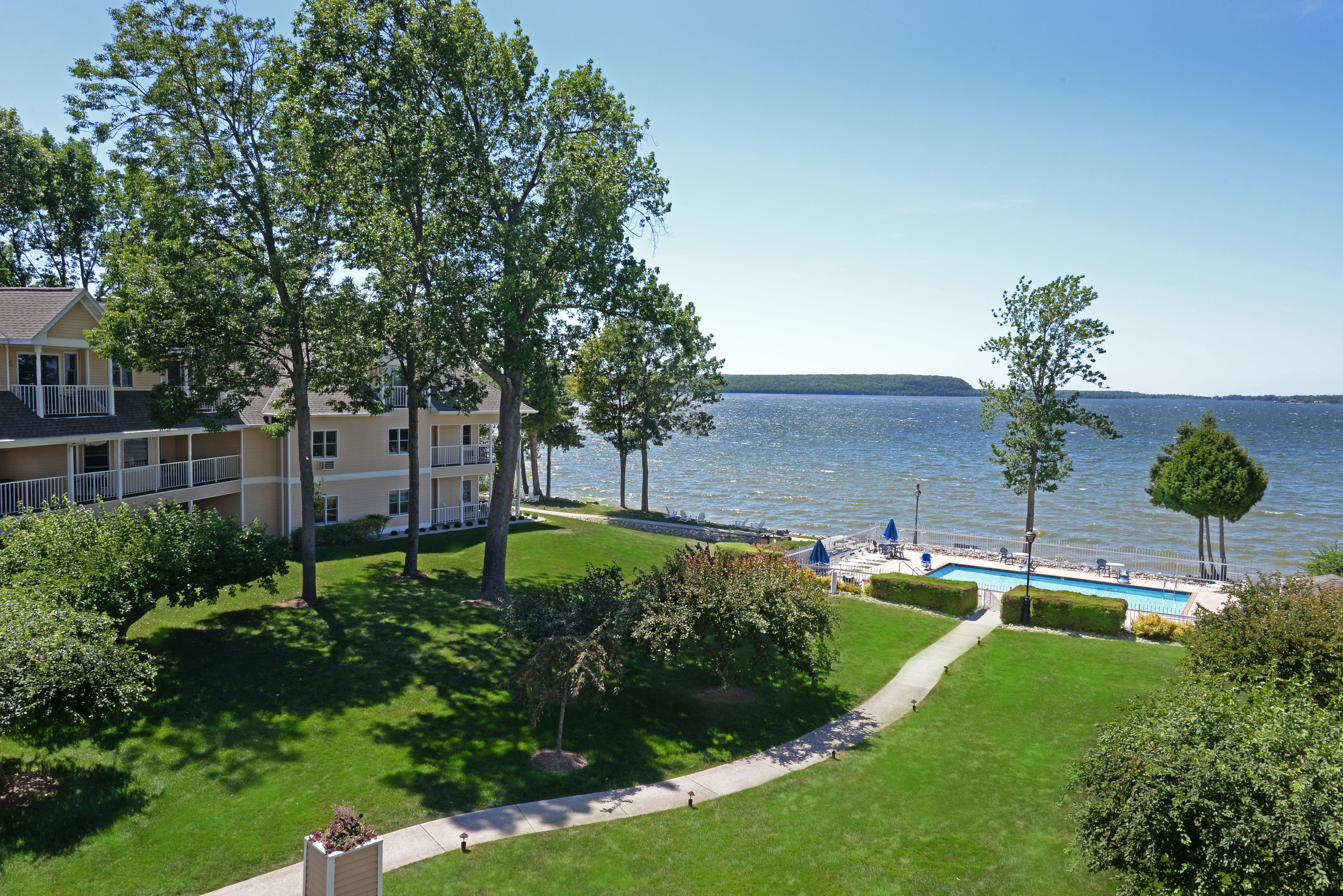 Un hôtel doté d’une piscine, d’une pelouse et offrant une vue sur le lac.