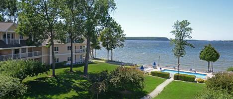 Ein Hotel mit Pool, Rasen und Seeblick.