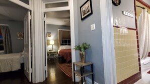 A bedroom with a bed, a nightstand, a lamp, and a window with curtains. - Simmons Motel (Hershey)