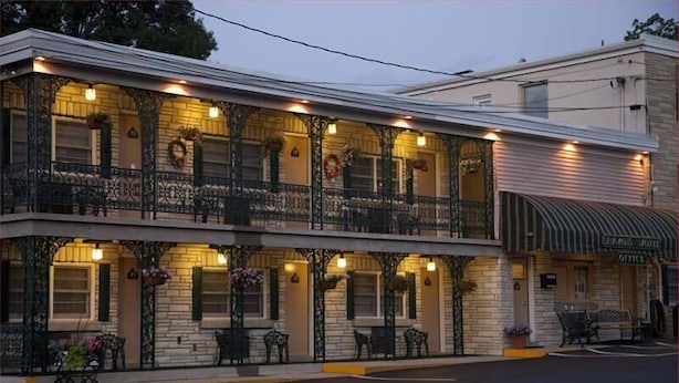 A two-story building with a balcony, outdoor seating, and a sign for the Chicago Motel Office. - Simmons Motel (Hershey)