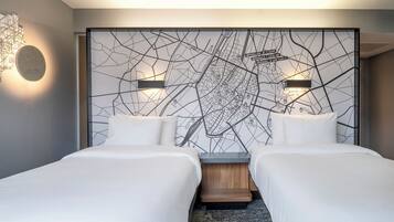 Habitación de hotel moderna con dos camas, un gran mapa mural y una lámpara de diseño original.