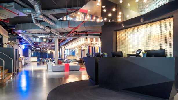 A modern hotel lobby with a reception desk, seating area, and visible HVAC ducts. - Pestana Brussels Schuman (Brussels)
