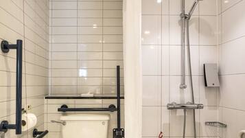 A bathroom with a toilet, a shower with a handheld showerhead, and a towel rack.