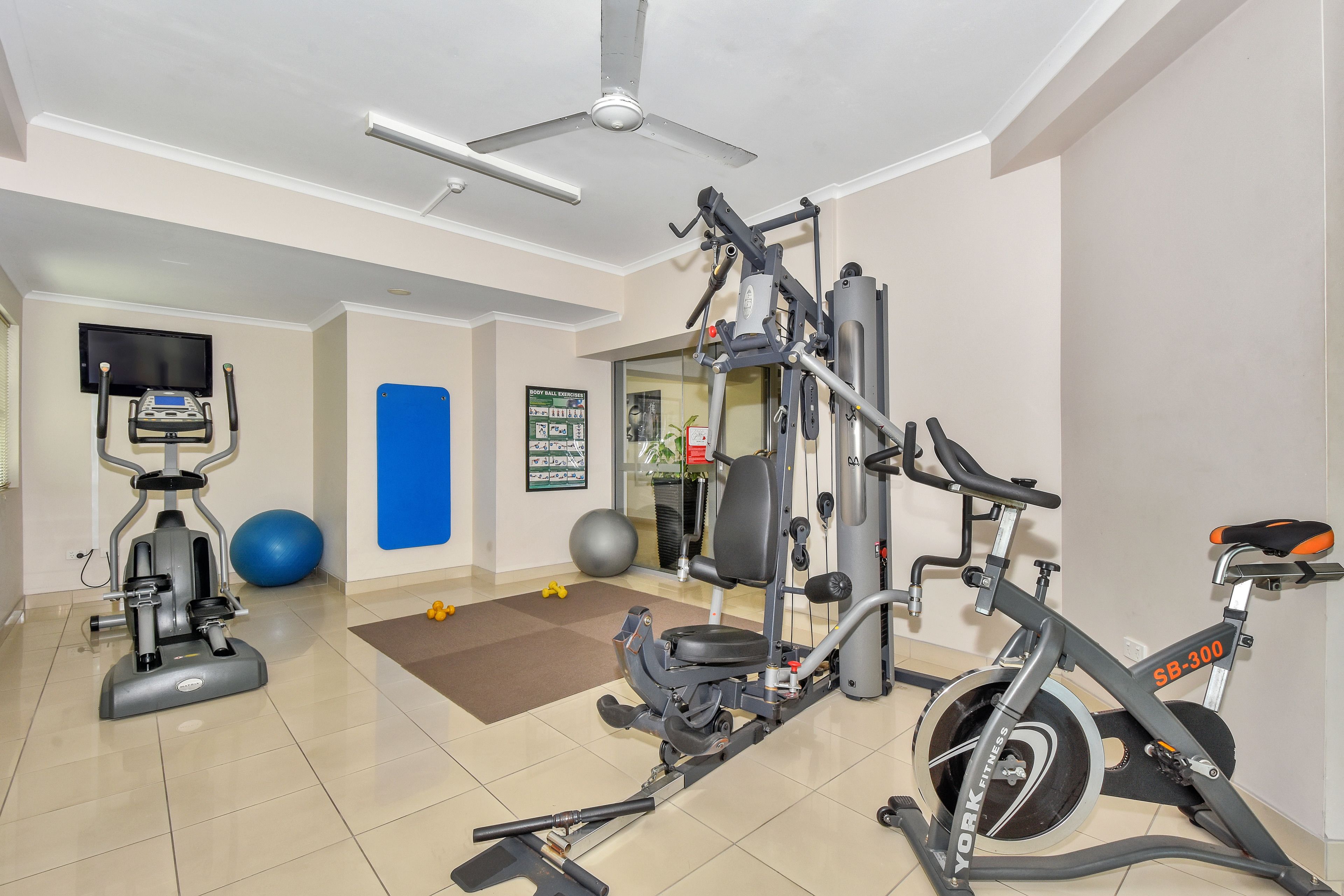 A gym with exercise equipment, a treadmill, and a stationary bike.