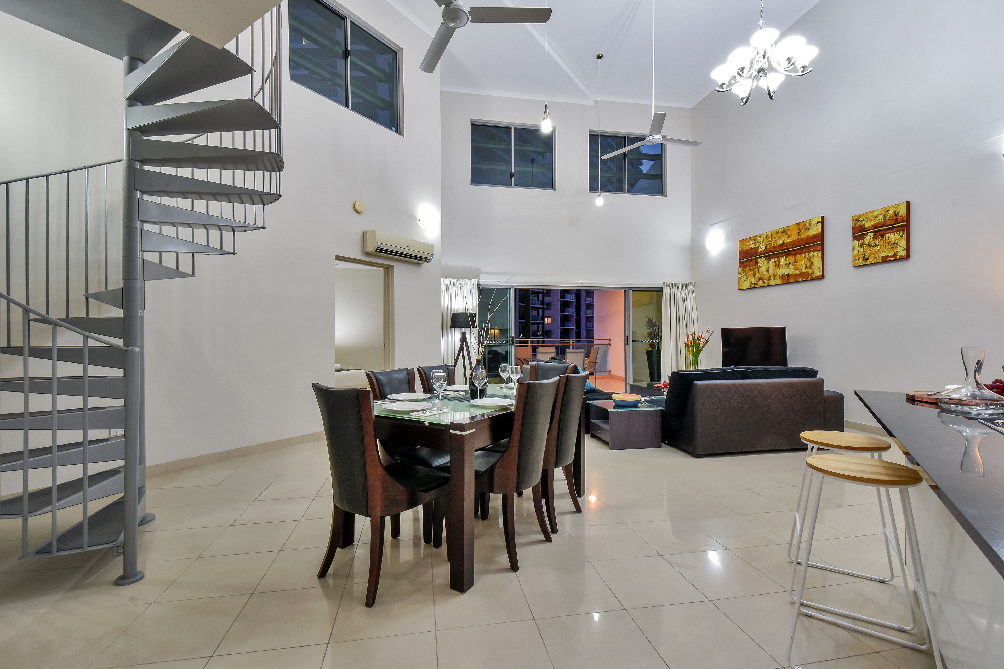 A modern interior with a spiral staircase, dining area, and living space.