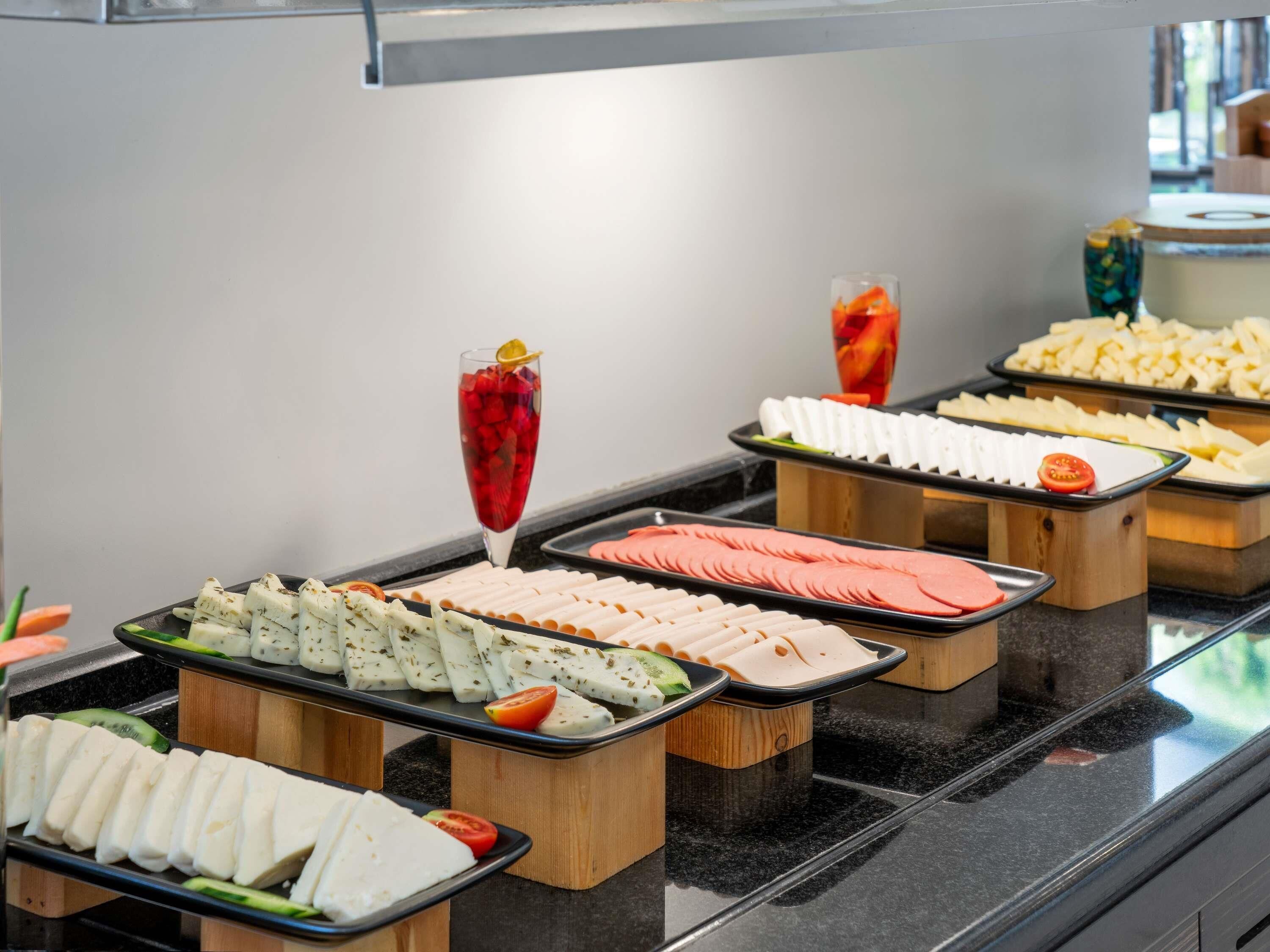 A buffet with various food items and a drink.