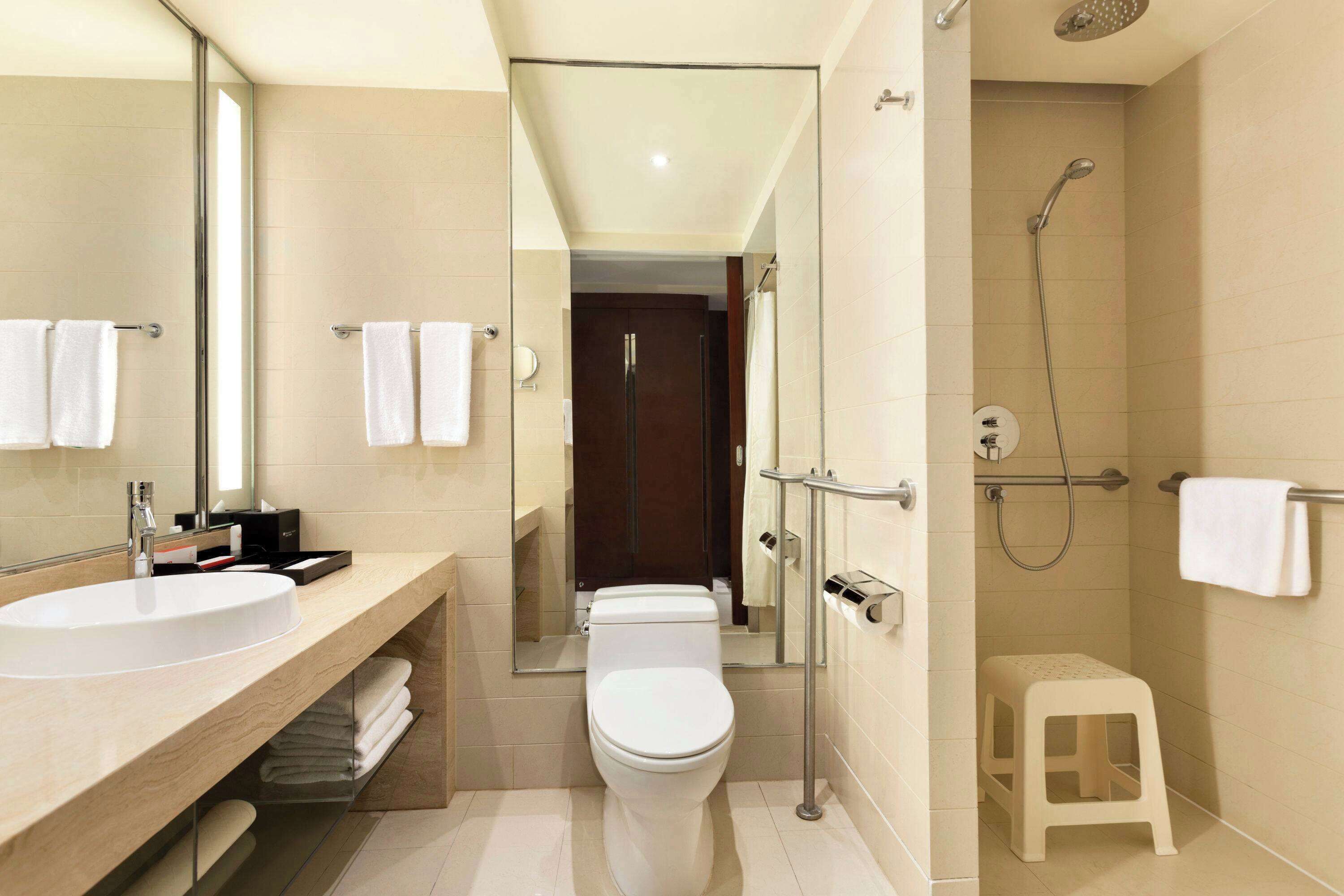 Ein modernes Badezimmer mit großem Waschbecken, Toilette und Duschbereich.