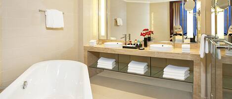 A modern bathroom with a freestanding bathtub, a large mirror, and a vanity with a sink and countertop.
