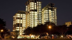 Un hôtel à plusieurs étages, doté de fenêtres illuminées et d’une architecture moderne.