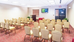A conference room with rows of chairs, a podium, and a Holiday Inn Express sign. - Holiday Inn Express & Suites Elkton - University Area by IHG (Elkton)