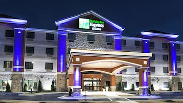 Un hotel Holiday Inn Express & Suites con fachada de piedra, numerosas ventanas y una entrada destacada con marquesina.