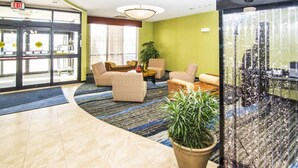 A lobby with a curved floor, a reception desk, and seating areas. - Holiday Inn Express & Suites Elkton - University Area by IHG (Elkton)