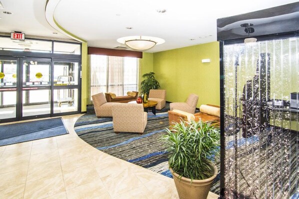 A lobby with a curved floor, a reception desk, and seating areas. - Holiday Inn Express & Suites Elkton - University Area by IHG (Elkton)