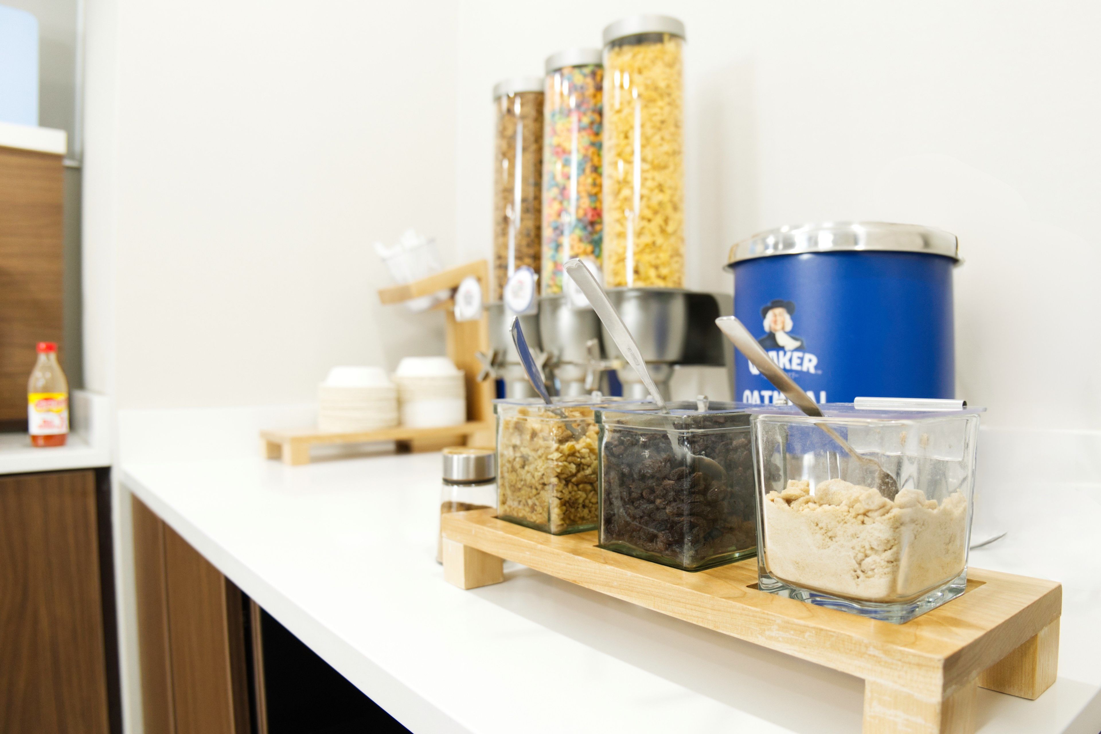 A buffet setup with various food containers and utensils on a wooden stand.