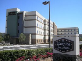 Edificio de Hampton Inn Suites con un cartel en la entrada.