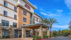 A Hampton Inn & Suites with a clear sky, a covered entrance, and a parking lot. - Hampton Inn & Suites Riverside/Corona East (Riverside)