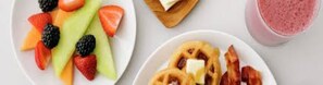 A breakfast setting with a plate of fruit and a bowl of pancakes. - Hampton Inn & Suites Riverside/Corona East (Riverside)