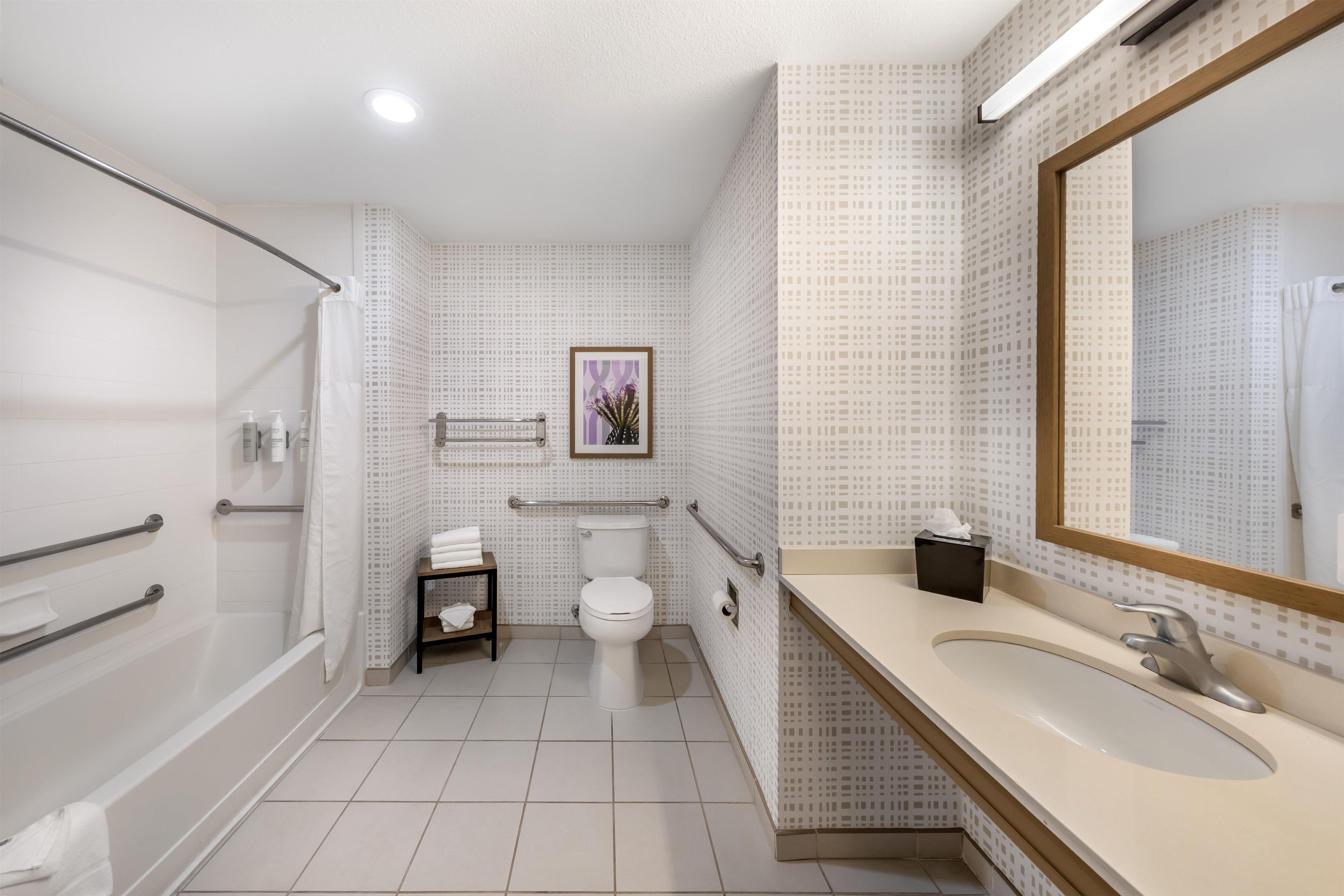 A modern bathroom with a shower, toilet, and sink.