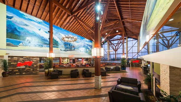 A spacious lobby with a high ceiling, large windows, and a mural depicting a mountainous landscape. - Super 8 by Wyndham Sherwood Park/Edmonton Area (Sherwood Park)