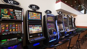 A row of slot machines in a casino with illuminated screens and various game options. - Super 8 by Wyndham Sherwood Park/Edmonton Area (Sherwood Park)