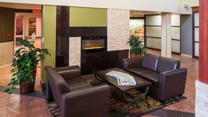 A lobby with a fireplace, leather seating, and potted plants. - Super 8 by Wyndham Sherwood Park/Edmonton Area (Sherwood Park)