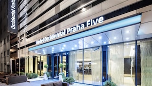 The exterior of Hotel Occidental Praha Five with a modern facade, large glass windows, and outdoor seating area. - Occidental Praha Five (Prague)