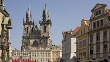 A historic building with multiple spires and a crowd in front.