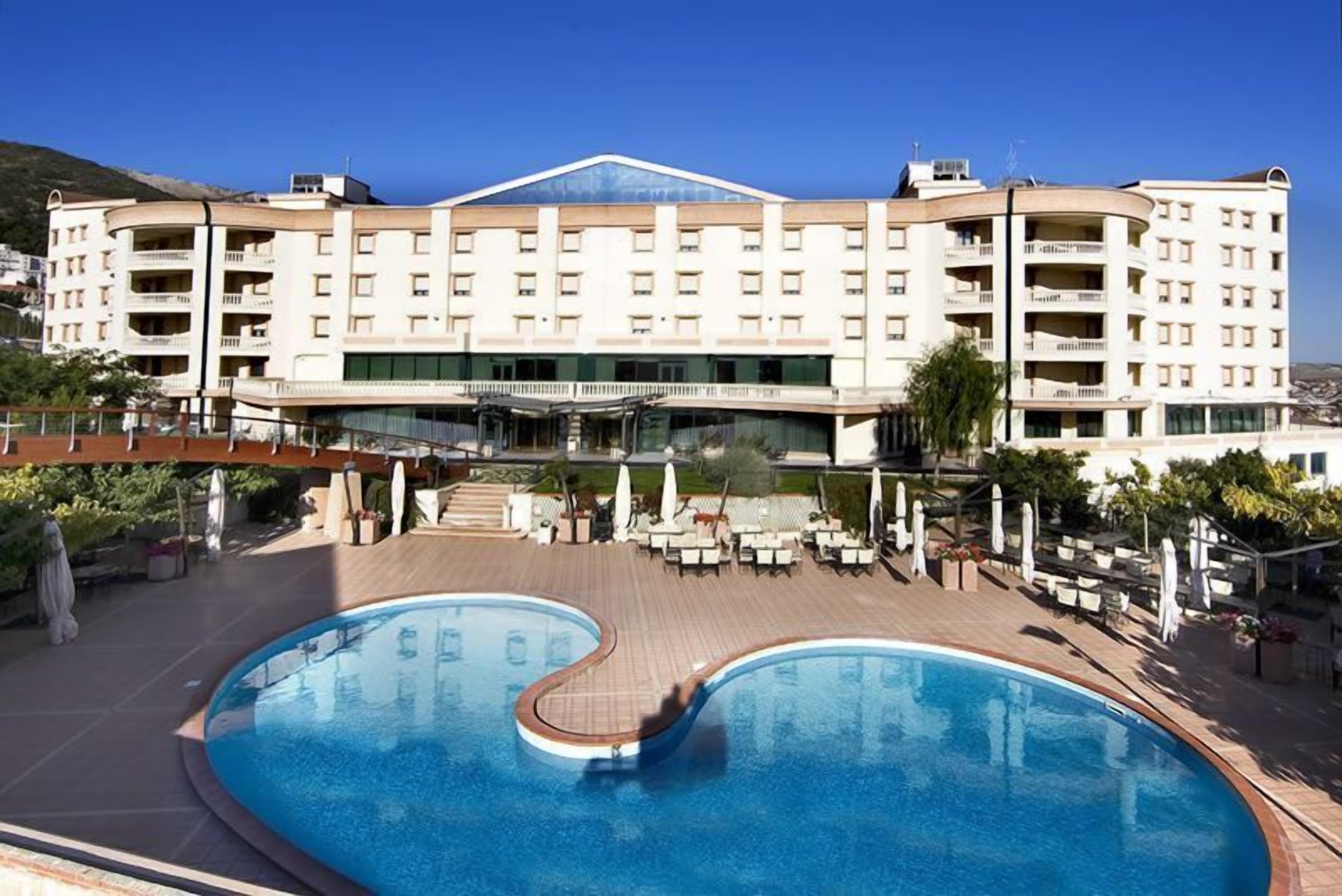 Un hôtel doté d’une grande piscine, de nombreux balcons et d’une terrasse.