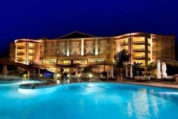 Un gran hotel con una piscina al frente.