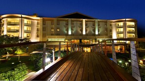 Un hotel de varios pisos con balcones y una terraza de madera.