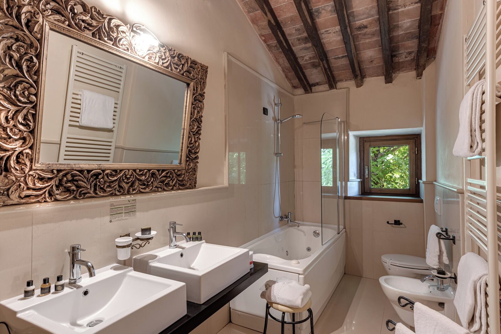 Une salle de bain avec deux lavabos, une baignoire, des toilettes et une douche.
