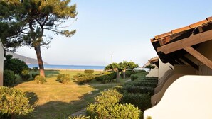 A landscaped garden with a pathway leading to a building with a sloped roof. - Hotel Marina di Lava (Appietto)