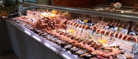 Ett urval av skaldjur, med olika sorters fisk och skaldjur, inklusive räkor, ostron och fisk.