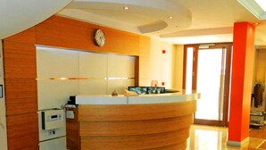 A modern kitchen with a wooden island, a clock, and a large window. - Hotel Baylan Izmir (Izmir)