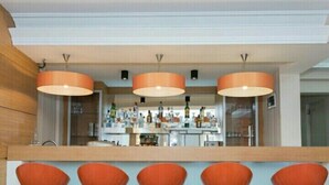 A bar area with orange bar stools and pendant lighting. - Hotel Baylan Izmir (Izmir)