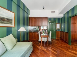 Una cucina moderna con mobili in legno, un tavolo da pranzo con sedie, una porta verde e un quadro incorniciato al muro.