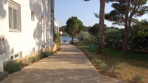 A stone pathway leading to a building with a white exterior.