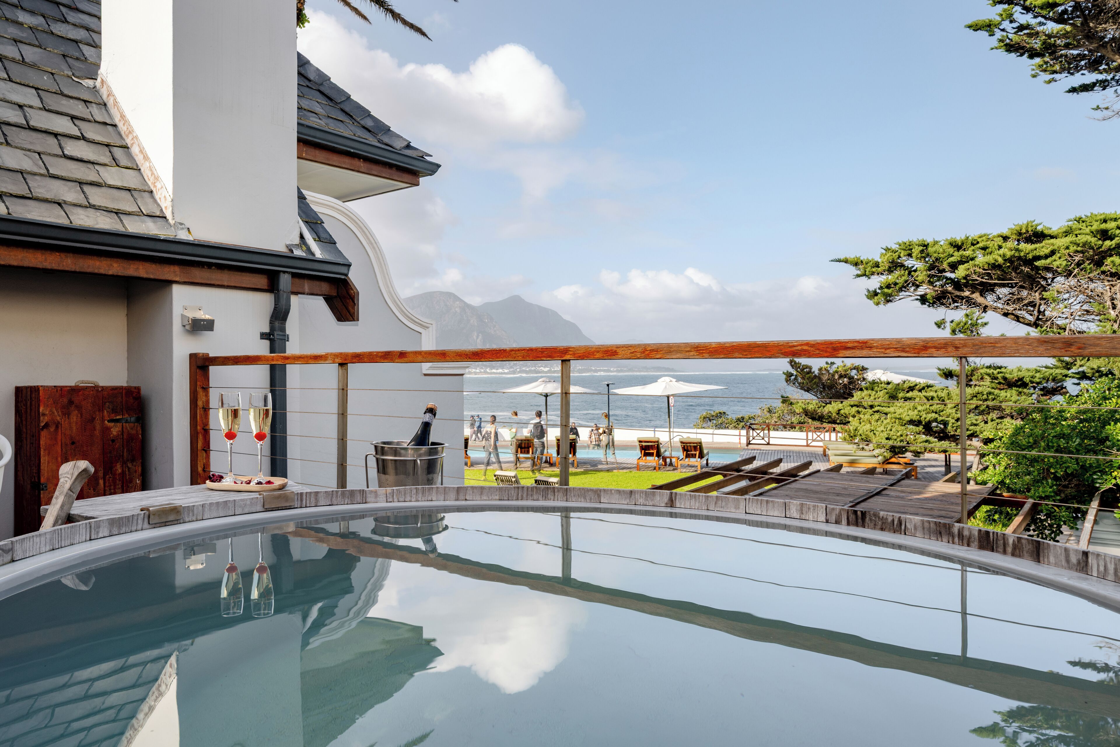 A swimming pool with a view of the beach and mountains.