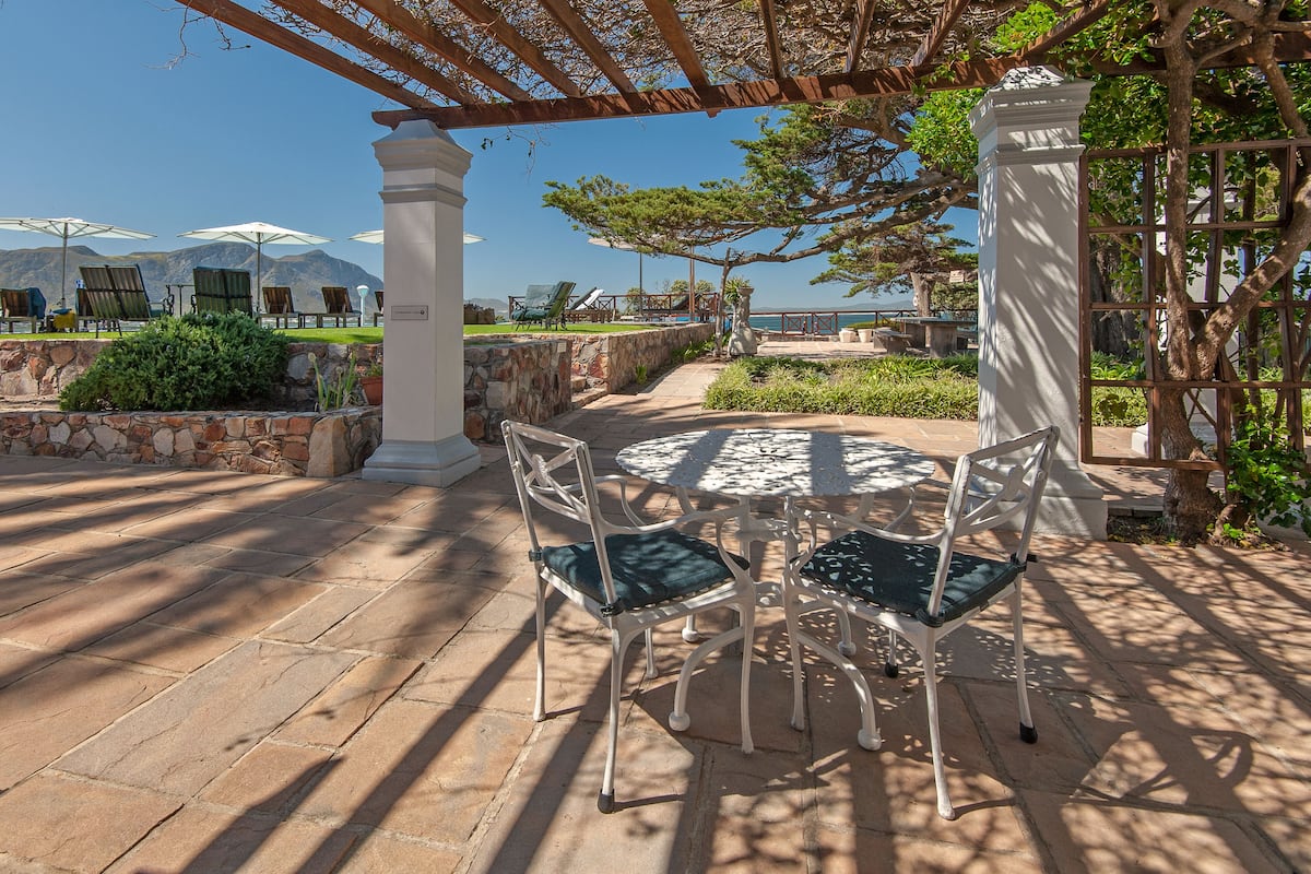 Un patio con mobiliario exterior, una pérgola y vistas a las montañas.