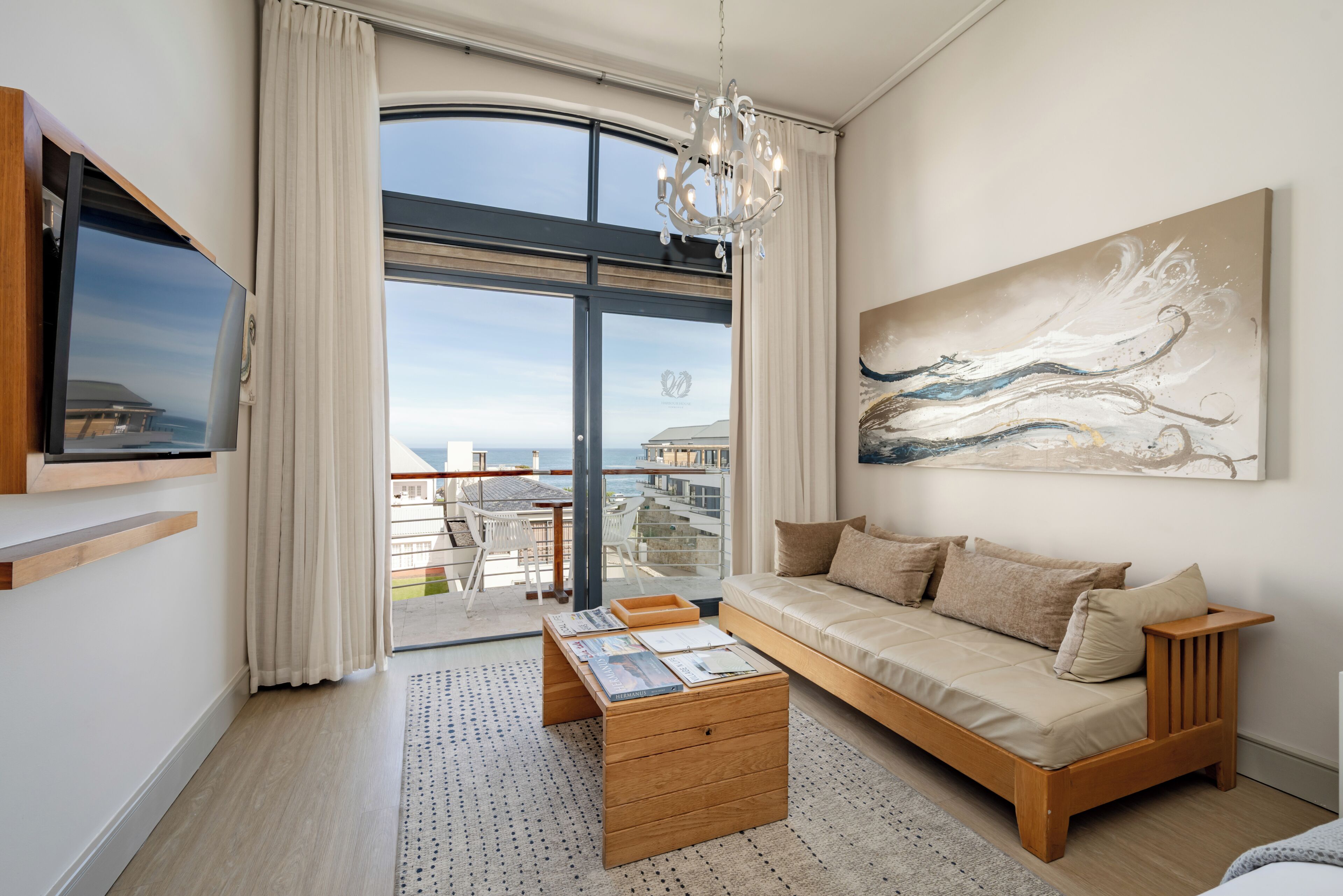 A modern living room with a sofa, coffee table, and artwork on the wall.