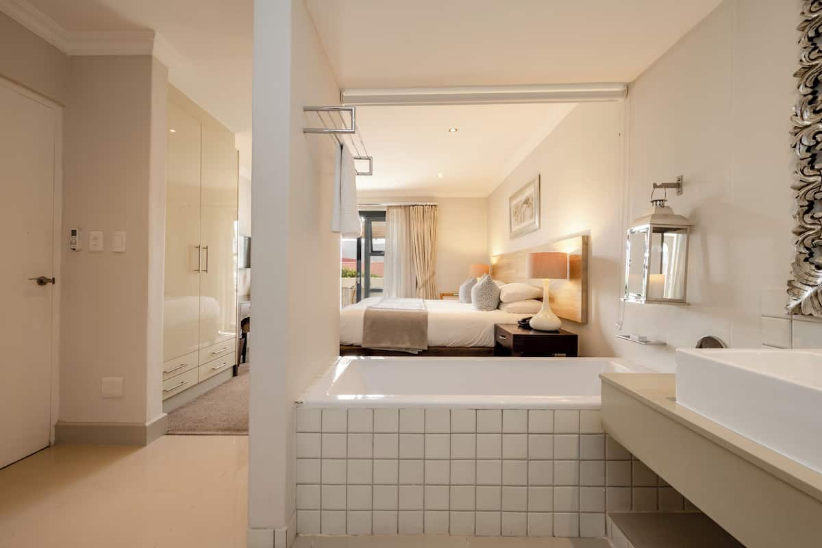 Un baño moderno con bañera, un espejo grande y tocador.